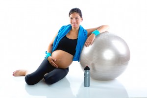 Beautiful pregnant woman at fitness gym relaxed