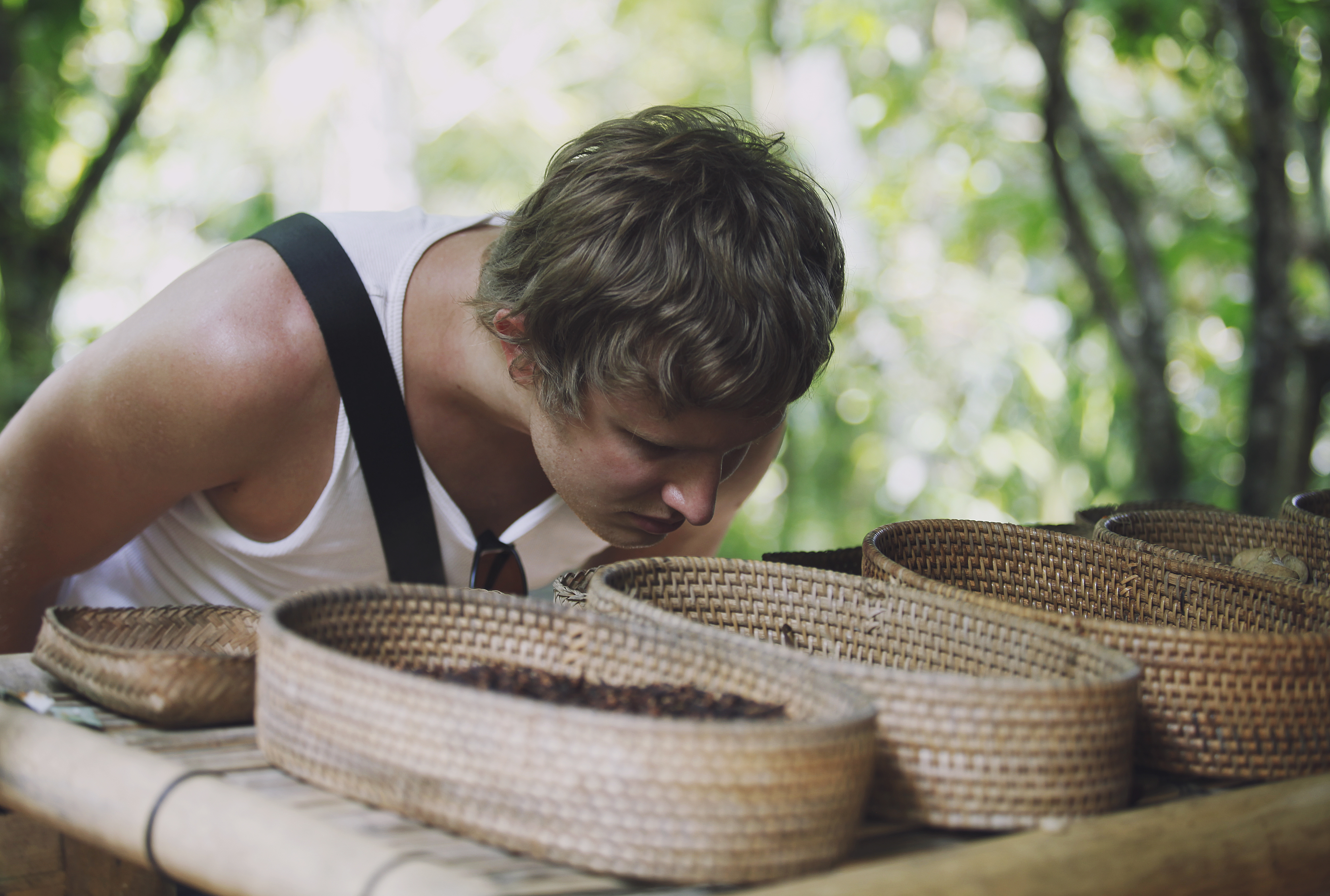 Man examines exotic spices in wicker baskets on the market